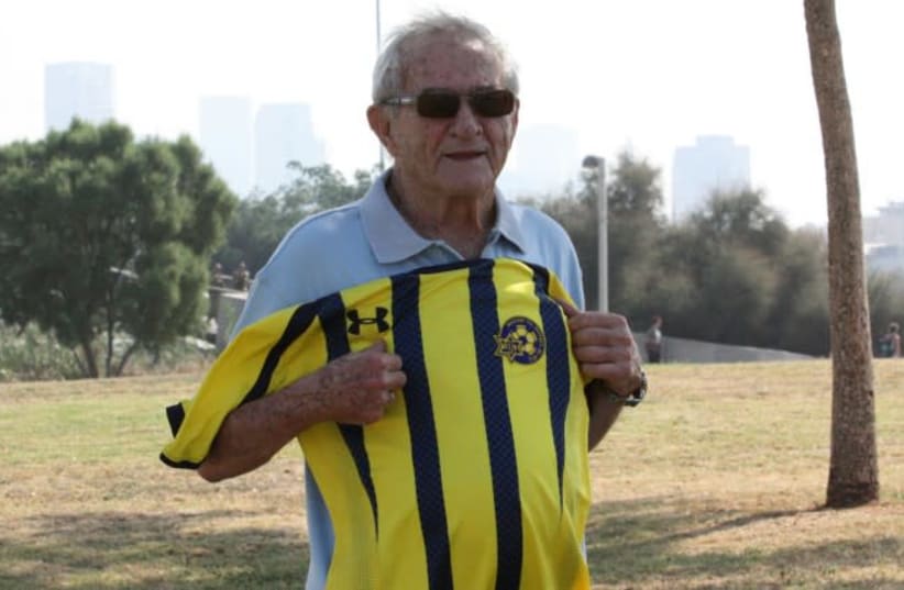 Yehoshua "Shaya" Glazer holding a Maccabi Tel Aviv shirt, a team to which he once belonged, 2012. (photo credit: MACCABI TEL AVIV WEBSITE)