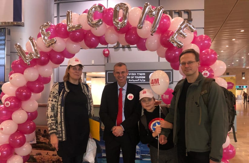 Minister of Tourism Yariv Levin (Center] with the 4 millionth tourist to arrive in Israel in 2018. (photo credit: Courtesy)