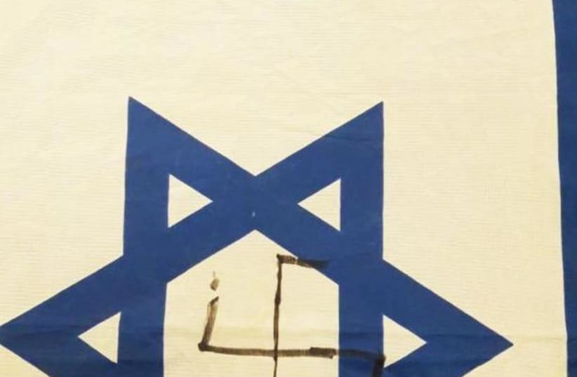 A defaced Israeli flag with the Nazi Swastika and a Hebrew caption saying "Death to Zionists."   (photo credit: Courtesy)