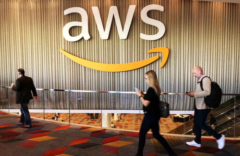 Attendees at Amazon.com Inc annual cloud computing conference walk past the Amazon Web Services logo in Las Vegas, Nevada, U.S., November 30, 2017.  (photo credit: SALVADOR RODRIGUEZ / REUTERS)