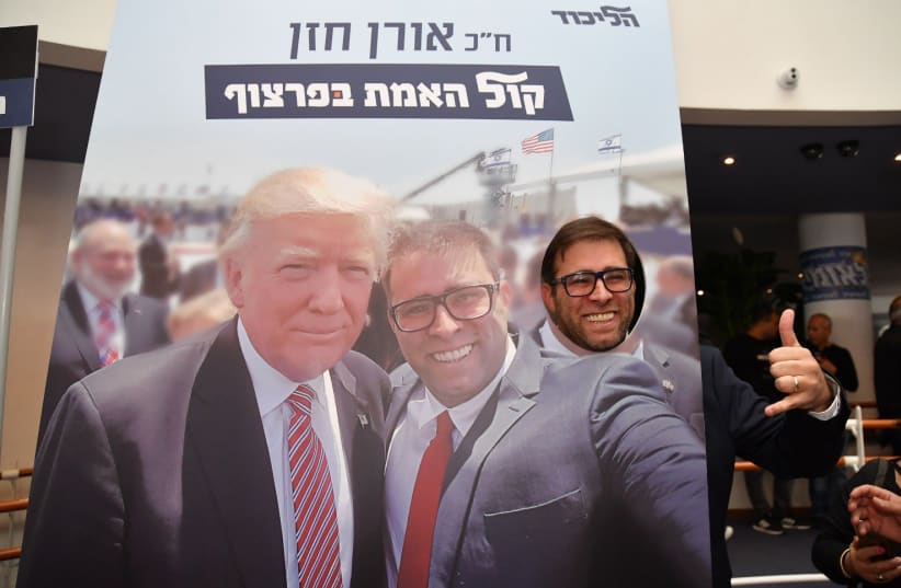 Oren Hazan posing with a poster of his selfie with US President Donald Trump at the Leumiada (photo credit: Lahav Harkov)
