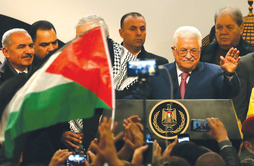 PALESTINIAN AUTHORITY PRESIDENT Mahmoud Abbas greets the audience during a ceremony in Ramallah on December 31, marking the 54th anniversary of Fatah’s founding (photo credit: MOHAMAD TOROKMAN/REUTERS)