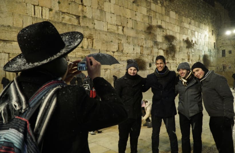 An orthodox Jew takes pictures of tourists at the Western Wall (photo credit: MARC ISRAEL SELLEM)