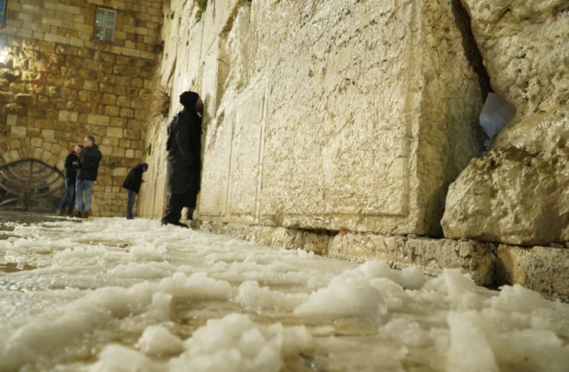 A note left in the cracks of the Western Wall; a few worshippers braved the cold to pray there. (photo credit: MARC ISRAEL SELLEM)