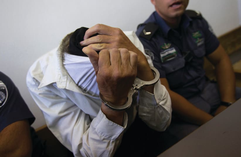 A SUSPECT IN a Jerusalem court. Can the Shin Bet’s motto – that it goes after all terrorism equally – be disproven?  (photo credit: RONEN ZVULUN/REUTERS)
