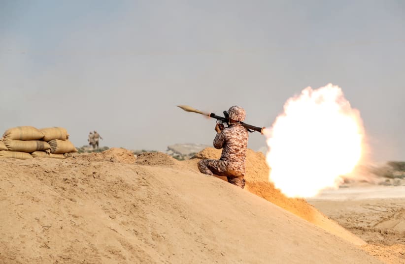A member of military units of the IRGC Ground Force fires a rocket launcher as they launched war games in the Gulf, December 22, 2018 (photo credit: HAMED MALEKPOUR/TASNIM NEWS AGENCY VIA REUTERS)