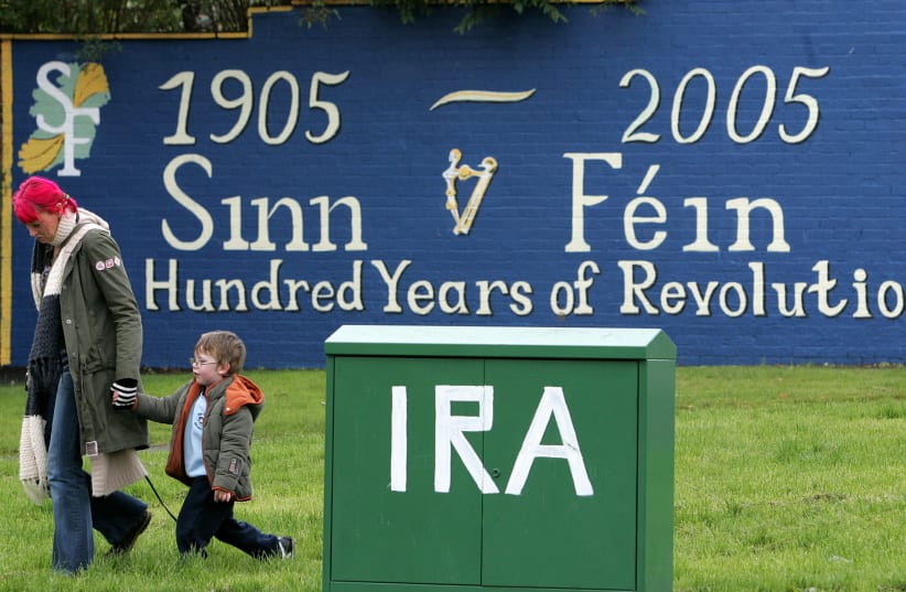 A file photograph, dated October 22, 2004, shows a mother and child walking past a new republican mural in west Belfast (photo credit: REUTERS)