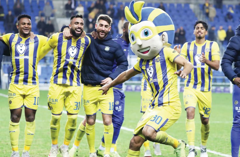 MACCABI TEL AVIV defender Maor Kandil dons the team mascot’s head to entertain his teammates following the yellow-and-blue’s 1-0 victory over Beitar Jerusalem in Premier League action on Monday night (photo credit: DANNY MARON)