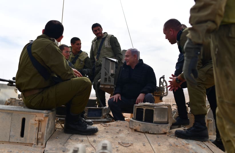 Benjamin Netanyahu speaks with soldiers on top of an IDF tank close to the Gaza Border January 23, 2019 (photo credit: GPO)