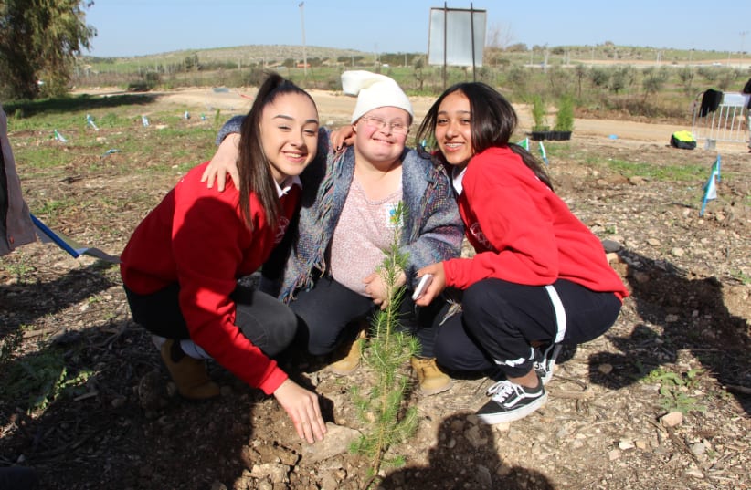 Tamar Lev-Zion of Rehovot (center) plants a tree for Tu Bishvat, with two teens from MDA Youth (photo credit: KKL-JNF)