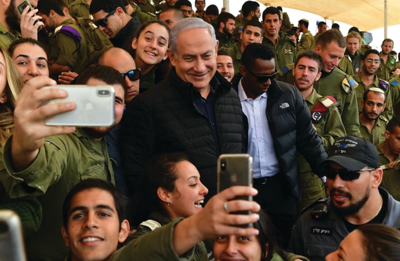 PRIME MINISTER Benjamin Netanyahu poses for selfies with soldiers at the Shizafon military base Wednesday (photo credit: KOBI GIDON / GPO)