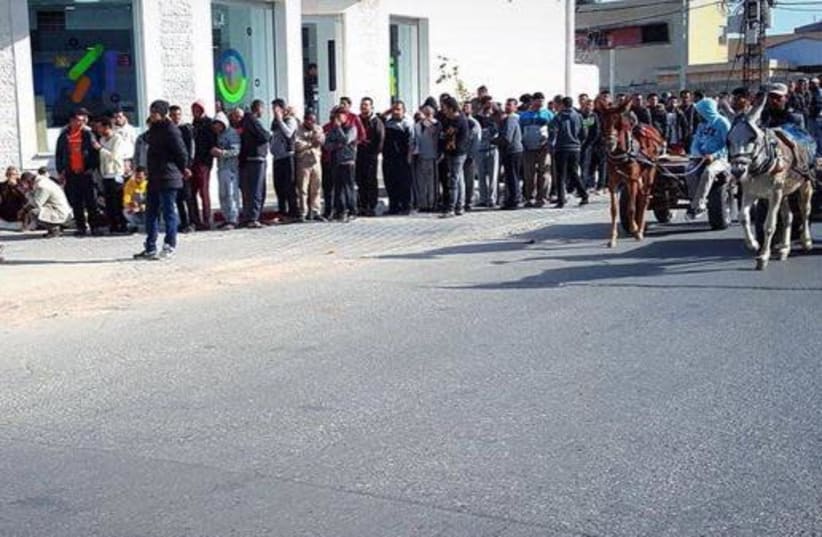 Gazan citizens line up to receive their Qatari grant for humanitarian aid (photo credit: Courtesy)