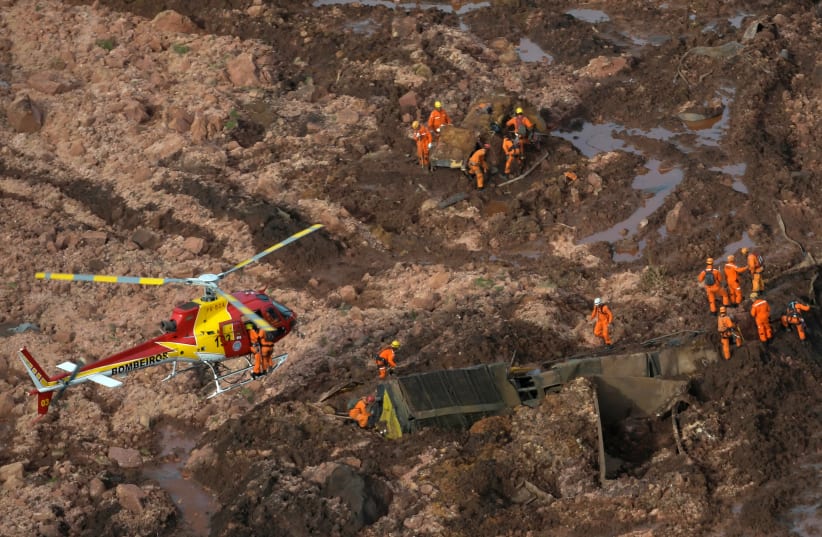 Rescue crew work in a tailings dam owned by Brazilian miner Vale SA that burst, in Brumadinho (photo credit: WASHINGTON ALVES / REUTERS)
