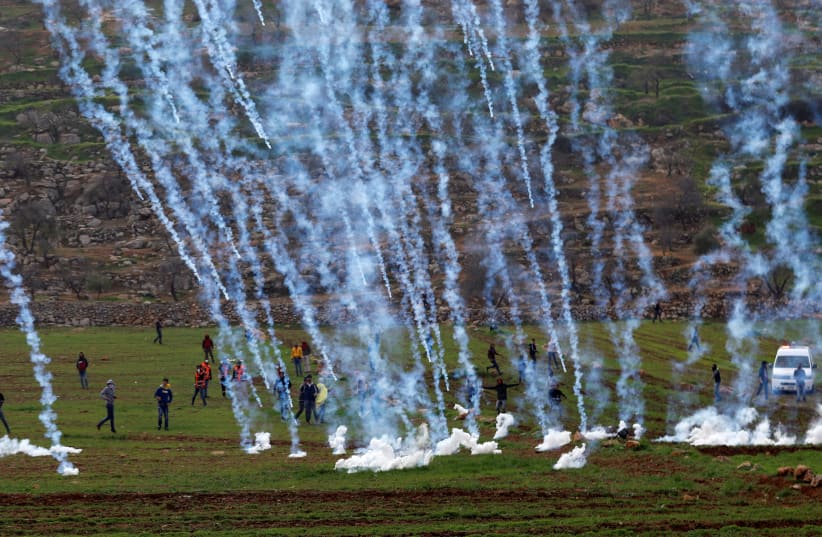 Tear gas canisters are fired by Israeli forces towards Palestinians during clashes in al-Mughayer village near Ramallah, January 27, 2019.  (photo credit: MOHAMAD TOROKMAN/REUTERS)