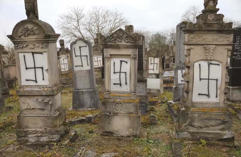 GRAVES DESECRATED with swastikas are seen in the Jewish cemetery of Herrlisheim.  (photo credit: REUTERS)