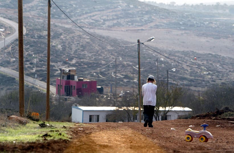 A Jewish settler walks at the Jewish settlement outpost of Adei Ad B in the West Bank (photo credit: REUTERS/NIR ELIAS)