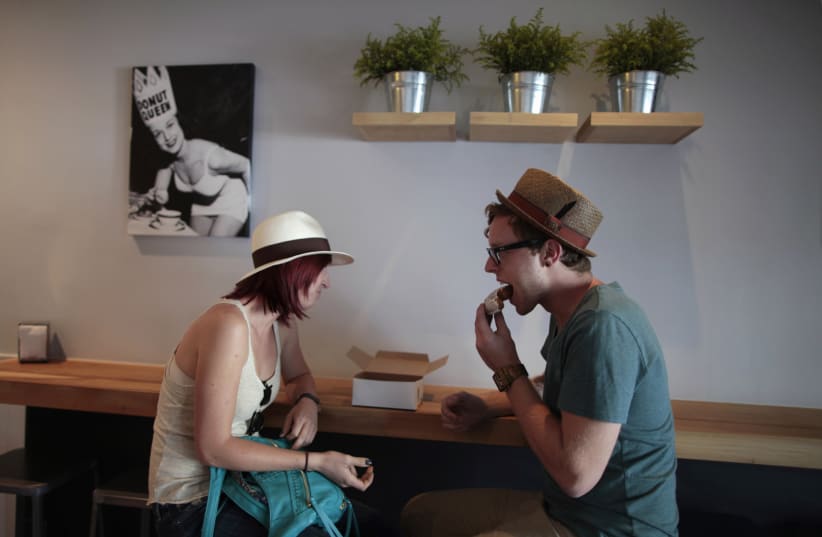 Ali Leopold, 24, (L) and Andrew Herrold, 25, eat faux donuts at Fonuts bakery, which offers unfried, gluten-free and vegan donuts, in Los Angeles, California September 19, 2011. An estimated 18 million people in the United States are sensitive to gluten, a hard-to-digest protein found in wheat, rye  (photo credit: LUCY NICHOLSON / REUTERS)