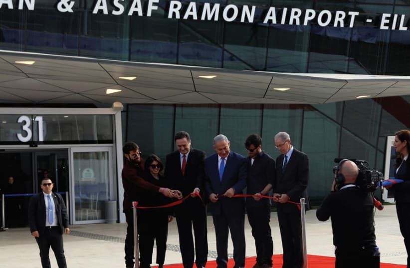 The three Ramon children, Tal, Noa and Yiftach, join Prime Minister Benjamin Netanyahu and Transportation Minister Israel Katz and Israel Airports Authority CEO Yaakov Ganot in cutting a red ribbon at the inauguration of the Ramon Airport on January 21, 2019 (photo credit: RONEN ZVULUN)