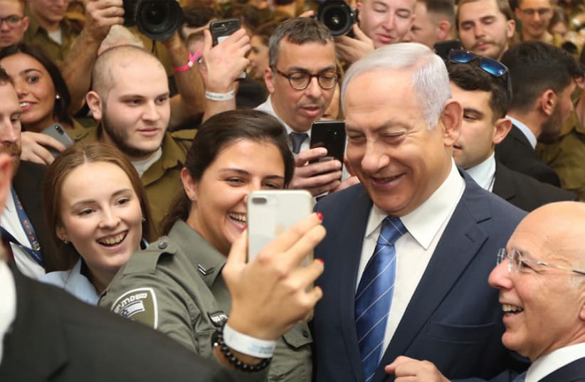 A border policewoman takes a selfie with Prime Minister Benjamin Netanyahu at an event for lone soldiers sponsored by Nefesh B’Nefesh and Friends of the IDF at Beit Hachayal in Tel Aviv on January 24 (photo credit: MARC ISRAEL SELLEM)