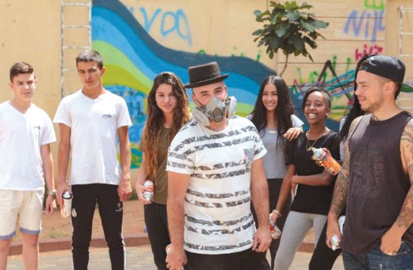 Artists 4 Israel’s Pariz One and Dershowitz help children in Netanya transform the outside of their school into a work of art (photo credit: ARTISTS 4 ISRAEL)
