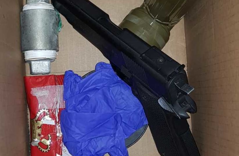 Weapons, ammunition and an improvised explosive was found in a home during a raid on Thursday (photo credit: ISRAEL POLICE)