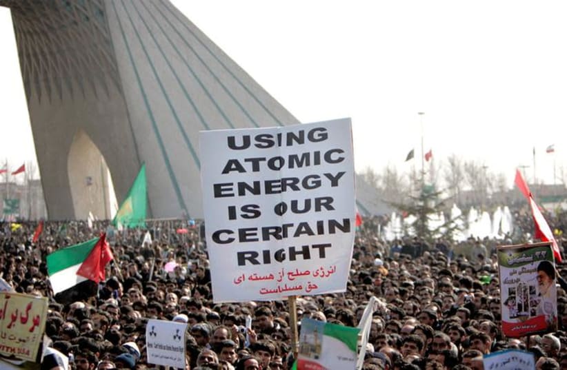  Iranians gather at Azadi (freedom) square to mark the 27th anniversary of Iran's Islamic Revolution, as they carry a placard in support of Iran's nuclear technology in Tehran (photo credit: REUTERS/RAHEB HOMAVANDI)