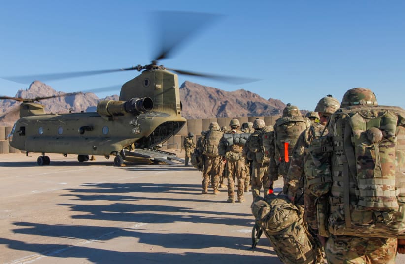 Soldiers attached to the 101st Resolute Support Sustainment Brigade, Iowa National Guard and 10th Mountain, 2-14 Infantry Battalion, load onto a Chinook helicopter to head out on a mission in Afghanistan, January 15, 2019. 1st Lt. Verniccia Ford/U.S.  (photo credit: VERNICCIA FORD/U.S. ARMY/HANDOUT VIA REUTERS)