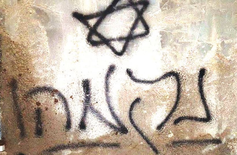 ‘REVENGE!’ PROCLAIMS the Hebrew graffiti on the burnt Dawabshe house in Duma, allegedly set alight in 2015 by Jewish terrorists. (photo credit: Wikimedia Commons)