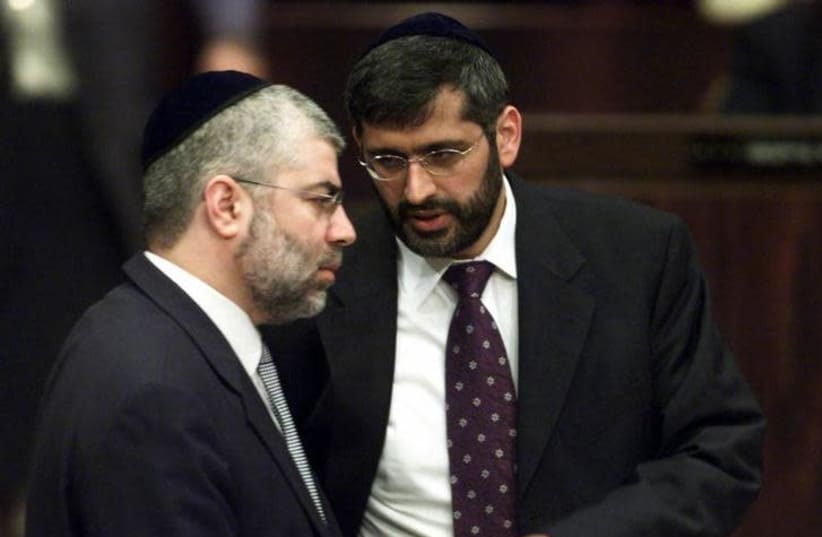 Shlomo Benizri (L) speaks with Eli Yishai (R) in the Knesset in 2001 (photo credit: NATALIE BEHRING / REUTERS)