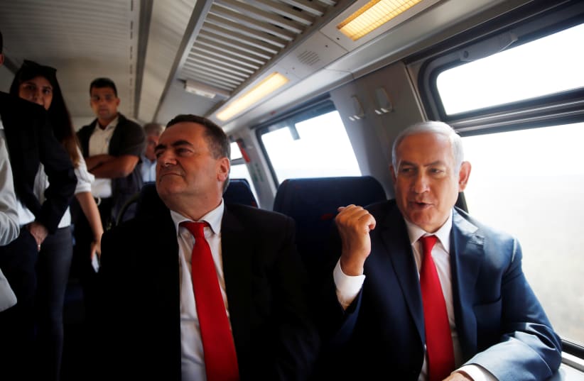 Prime Minister Benjamin Netanyahu (R) sits next to Transportation and Intelligence Minister Israel Katz (L) during a test-run of the new high-speed train between Jerusalem and Tel Aviv, near Lod, Israel September 20, 2018 (photo credit: RONEN ZVULUN/REUTERS)