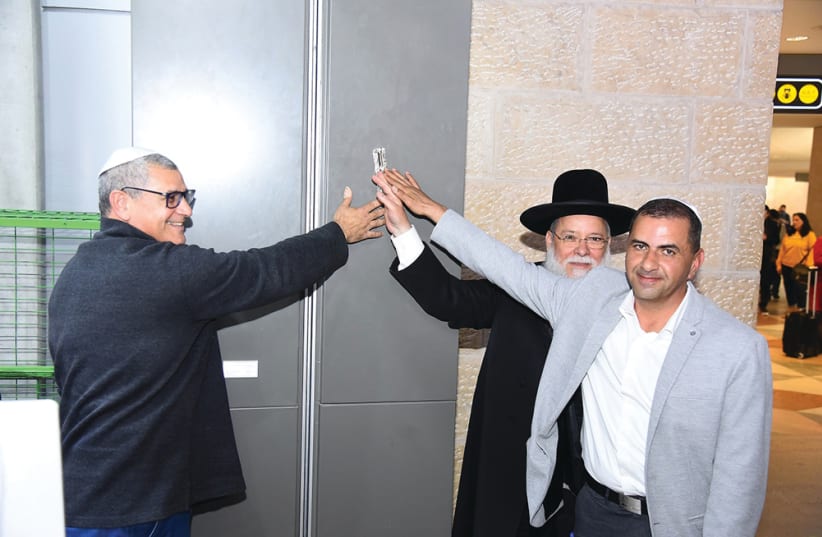 RANI ZIM, Office Depot owner, Elad Chief Rabbi Mordehai Malka and deputy director-general of Israel Airports Authority Yoram Shapira inaugurate a new store with a mezuzah (photo credit: MORAG BITAN)