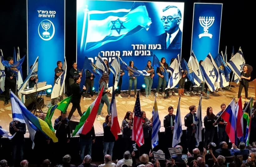 Betar youth wave Israeli flags and those of their respective countries as veteran members look on during the 95th anniversary of the youth movement in Jerusalem, February 17, 2019 (photo credit: Courtesy)