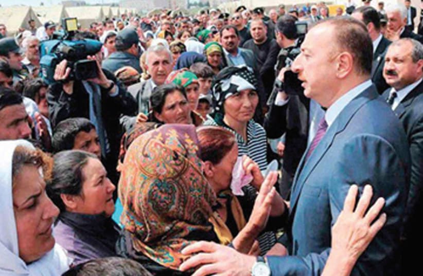 AZERBAIJAN’S PRESIDENT Ilham Aliyev meets with Azerbaijani refugees from Nagorno-Karabakh at a special camp for internally displaced persons (IDP) in 2018. (photo credit: SPUTNIK.AZ)