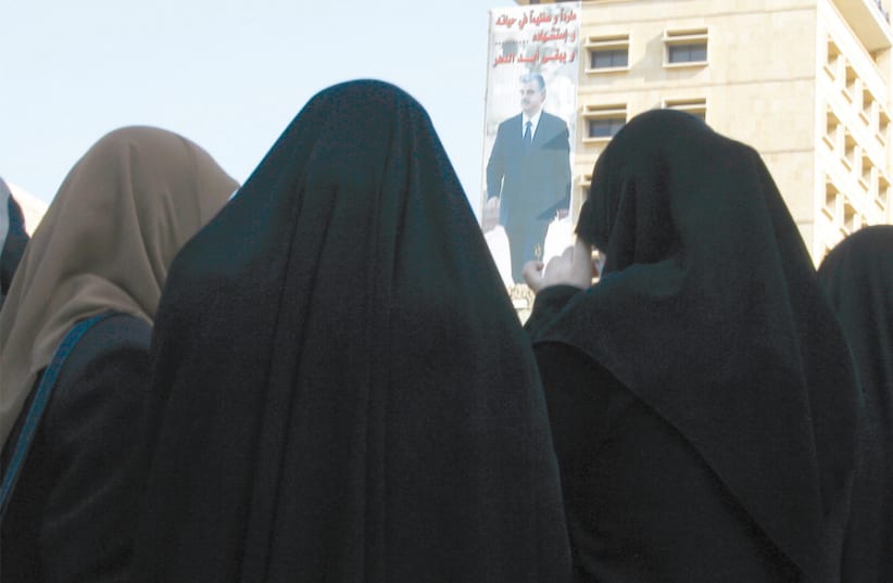 A GROUP of Hezbollah women supporters attend a rally near a poster of assassinated Lebanese prime minister Rafik Hariri in downtown Beirut in December 2006. (photo credit: REUTERS)