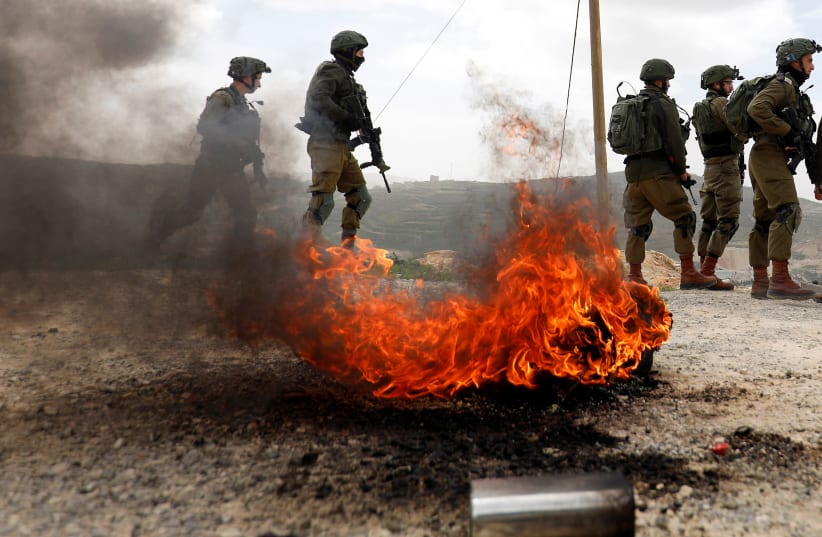 Israeli soldiers stand during clashes with Palestinians in the West Bank (photo credit: MOHAMAD TOROKMAN/REUTERS)