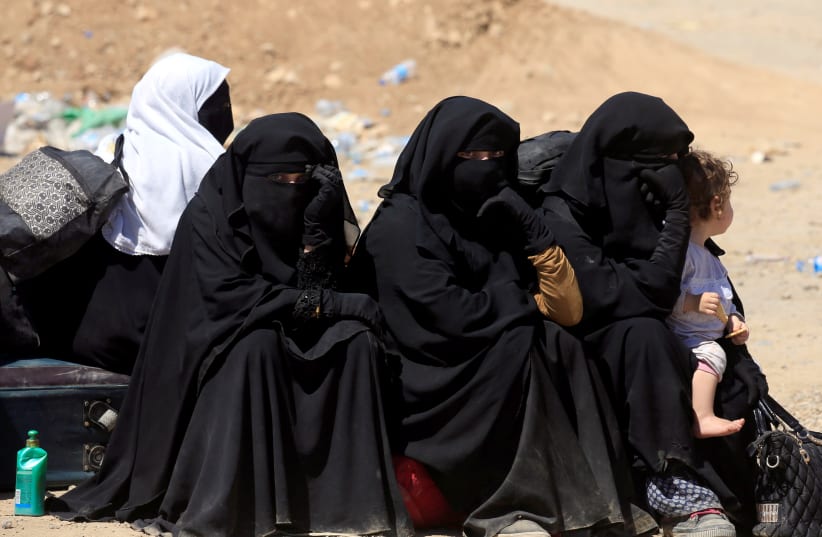 Displaced Iraqi women who fled from clashes sit together during a battle between Iraqi forces and Islamic state militants in western Mosul, Iraq, May 17, 2017 (photo credit: REUTERS/ ALAA AL-MARJANI)