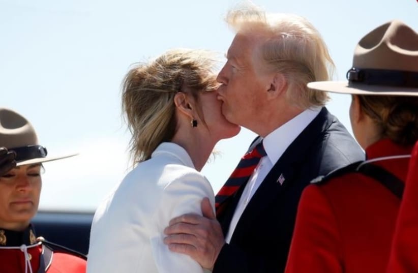 U.S. President Donald Trump kisses U.S. Ambassador to Canada Kelly Knight Craft as he arrives at Canadian Forces Base Bagotville in La Baie, Quebec, Canada, June 8, 2018. (photo credit: LEAH MILLIS/REUTERS)