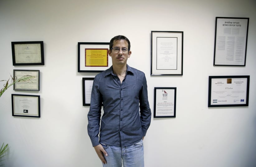 Hagai El-Ad, Executive Director of B'Tselem, a leading Israeli human rights organisation, poses in his office in Jerusalem December 16, 2015. An ultra-nationalist Israeli group has published a video accusing the heads of four of Israel's leading human rights organizations, including "B'Tselem", of b (photo credit: AMMAR AWAD / REUTERS)