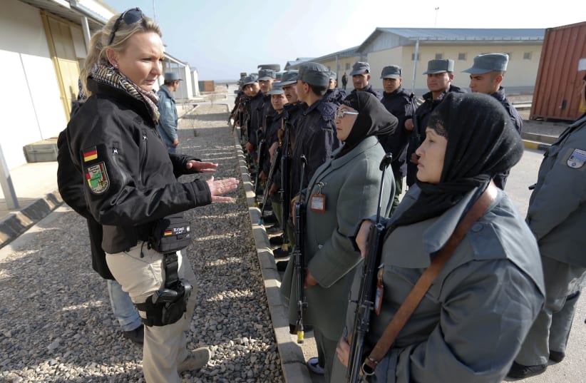 A German police instructor talks to female Afghan National Police (ANP) officers before a drill at a training centre near the German Bundeswehr army camp Marmal in Mazar-e-Sharif, northern Afghanistan December 11, 2012. German police is mentoring the training program for ANP, as part of an ongoing I (photo credit: FABRIZIO BENSCH / REUTERS)