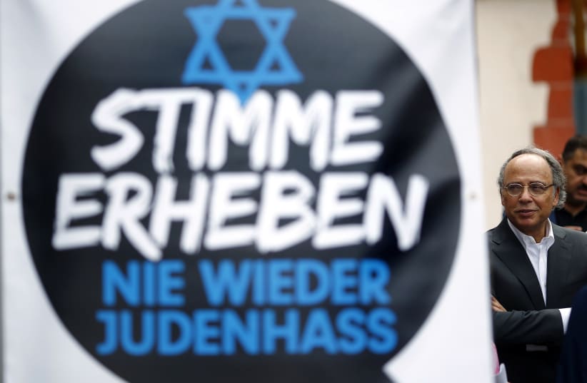 Dieter Graumann, head of Germany's Jewish community and vice president of the Jewish World Congress, stands next to a banner during a demonstration against anti-Semitism in Frankfurt, August 31, 2014 (photo credit: KAI PFAFFENBACH/REUTERS)