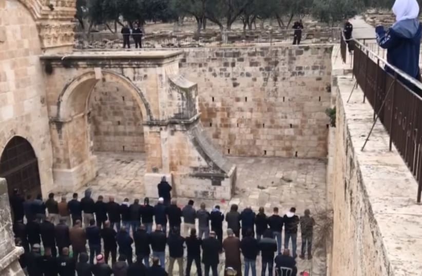 A prayer vigil at the Golden Gate patio area on the Temple Mount as police look on, February 21, 2019. A court order closed the area after the Waqf was cause conducting unauthorized construction and excavations (photo credit: screenshot)