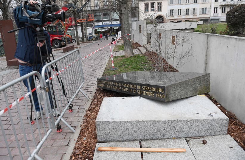 A cameraman films the memorial stone marking the site of Strasbourg's Old Synagogue, which was destroyed by the Nazis in World War II, after it was vandalised overnight on March 2, 2019 in Strasbourg, eastern France. The synagogue, which was the Jewish community's main place of worship in the city,  (photo credit: FREDERICK FLORIN/AFP)
