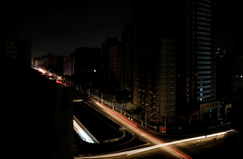 Car lights are seen on one of the main roads of the city during the second day of a blackout in Caracas, Venezuela March 9, 2019 (photo credit: REUTERS/CARLOS JASSO)