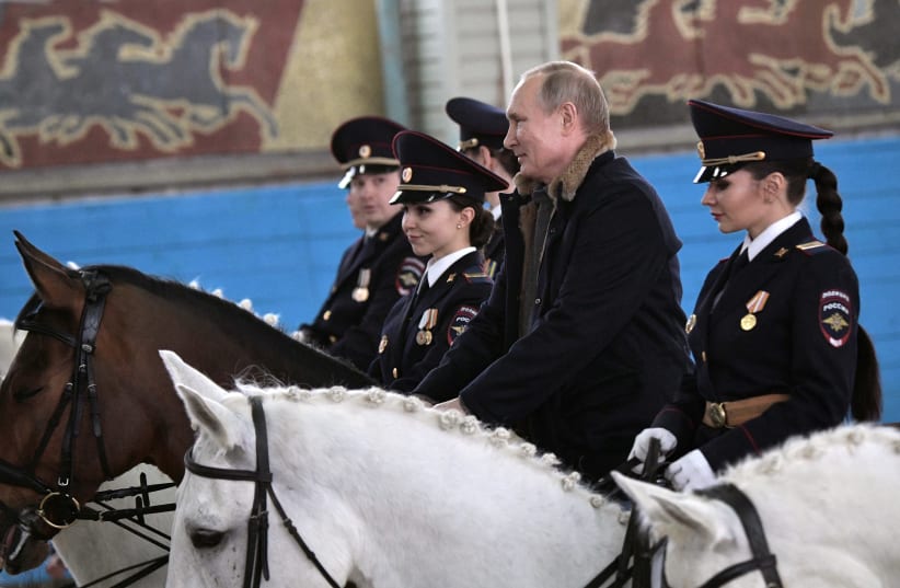 Putin meeting with Russian policewomen on Women's Day (Sputnik Photo Agency/REUTERS) (photo credit: SPUTNIK PHOTO AGENCY / REUTERS)