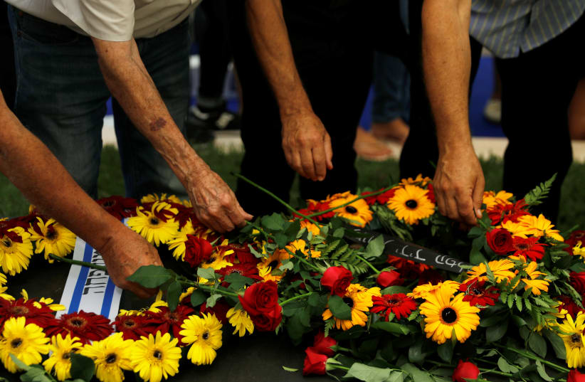 Members of the Shimon Peres's family lay flowers on his grave (photo credit: RONEN ZVULUN / REUTERS)