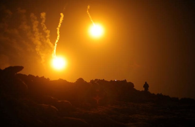 Flares are seen in the sky during fighting in the Islamic State's final enclave, in the village of Baghouz, Deir Al Zor province, Syria March 11, 2019 (photo credit: REUTERS/RODI SAID)