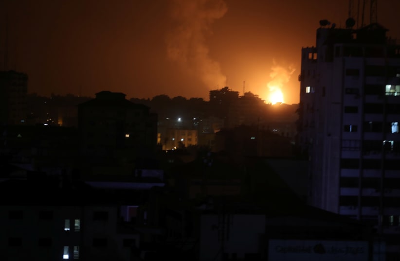 Smoke and flame are seen during an Israeli air strike in Gaza (photo credit: MOHAMMED SALEM/ REUTERS)