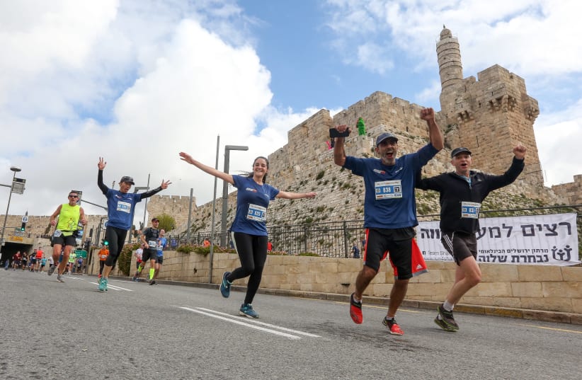 Jerusalem Marathon runners run past the Jerusalem's Old City walls, March 15th, 2019 (photo credit: MARC ISRAEL SELLEM/THE JERUSALEM POST)