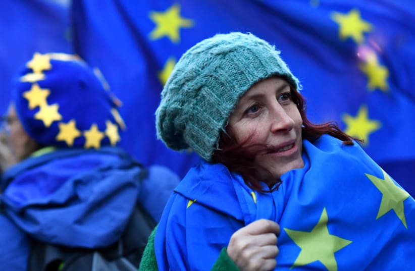 An anti-Brexit protester wears an EU flag outside the Houses of Parliament in London (photo credit: DYLAN MARTINEZ/REUTERS)