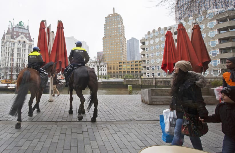 Dutch mounted police patrol in central Rotterdam ahead of the Europa League soccer match between Feyenoord and AS Roma in Rotterdam, February 26, 2015. Supporters of Rotterdam soccer team Feyenoord went on a drunken rampage in Rome's historic centre before a Europa League match against AS Roma last  (photo credit: YVES HERMAN/REUTERS)